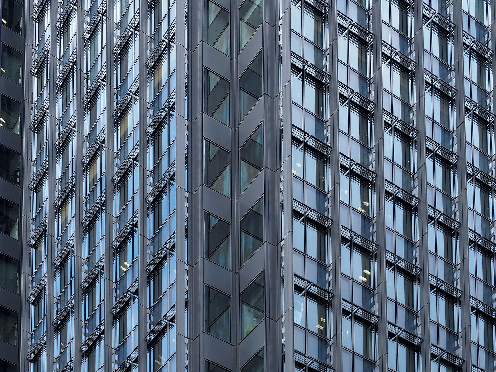 Close-up of a modern skyscraper's glass and steel facade in downtown Tokyo, Japan.