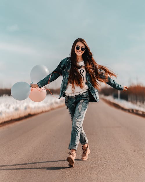 Free Woman With Long Hair in Denim Jacket and Ripped Denim Jeans Stock Photo