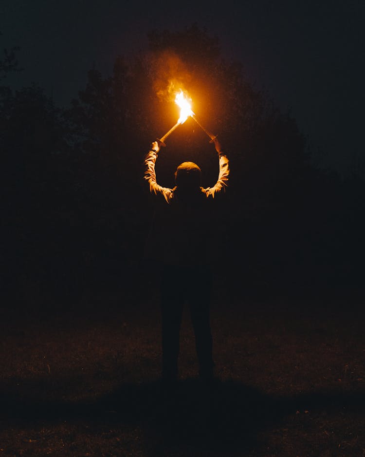 A Person Holding Burning Torches