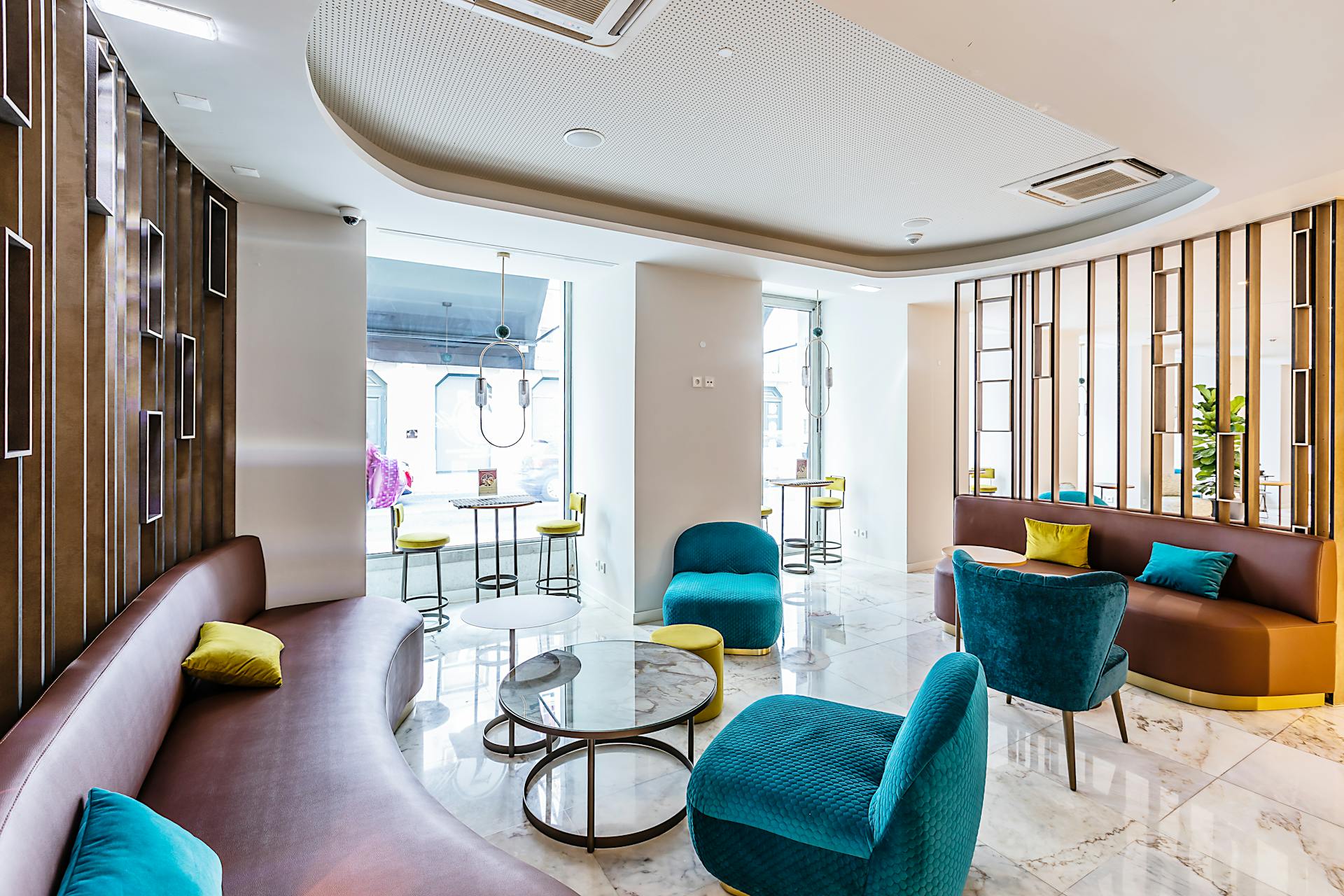 A spacious and stylish hotel lobby in Lisbon featuring modern interior design with vibrant seating and elegant decor.