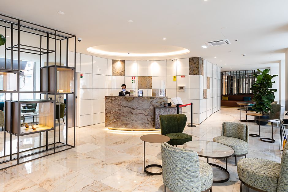 Elegant hotel lobby in Lisbon with stylish interior design and reception desk.