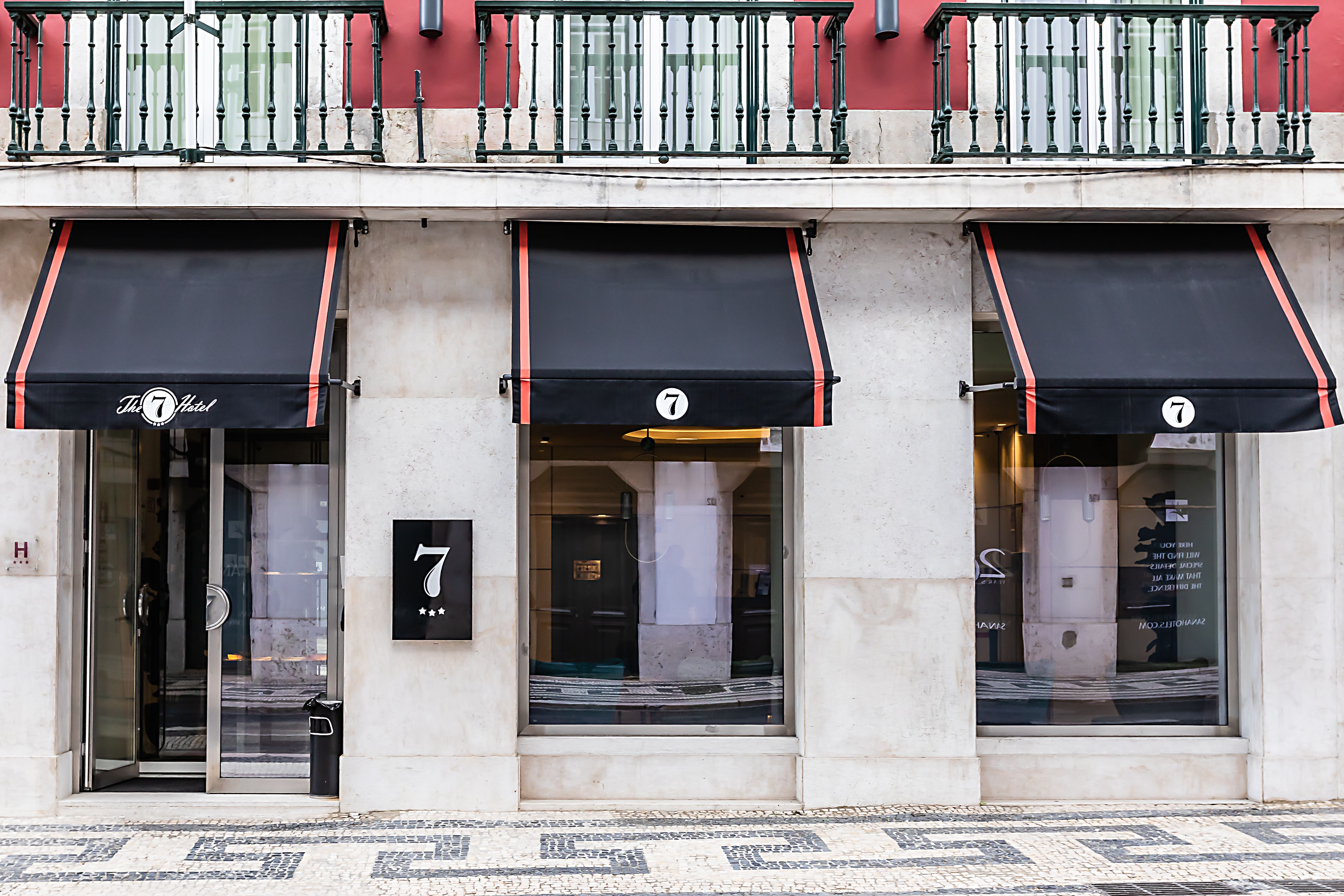 Fachada elegante do The 7 Hotel em Lisboa, Portugal, destacando luxo e história para viajantes de alto padrão.