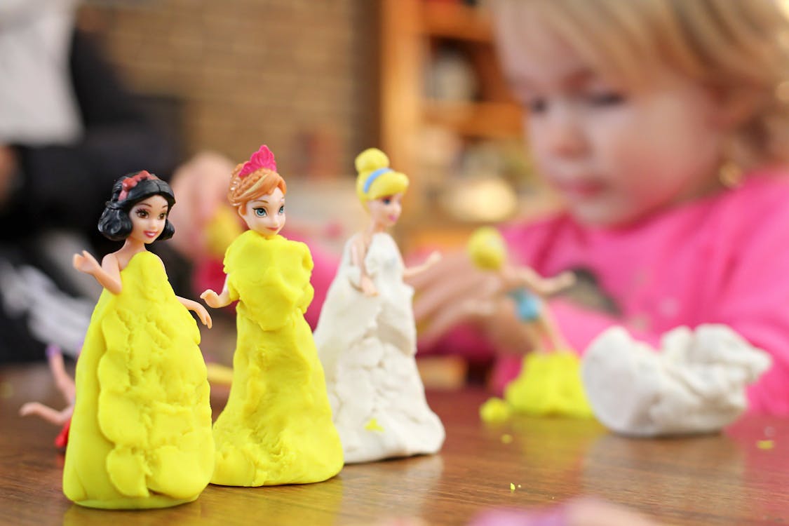 Free Selective Focus Photography of Three Disney Princesses Figurines on Brown Surface Stock Photo