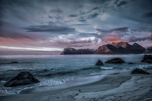 Free Beautiful twilight view of Myrland beach with rocky formations and the majestic Lofoten mountains. Stock Photo