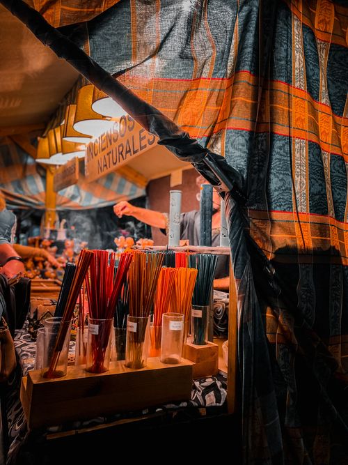 Free Colorful selection of natural incense sticks displayed at a vibrant market stall with woven fabric decor. Stock Photo