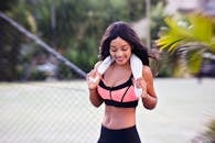 一位穿着运动服的年轻女子微笑着享受户外锻炼，展现了健康与活力