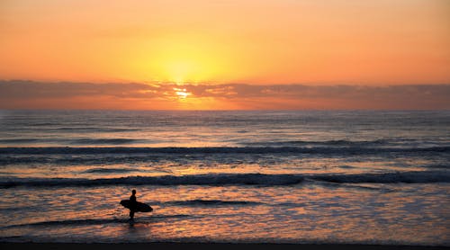 Zdjęcie Surfer W Fotografii O Zasadzie Trójpodziału Podczas Zachodu Słońca