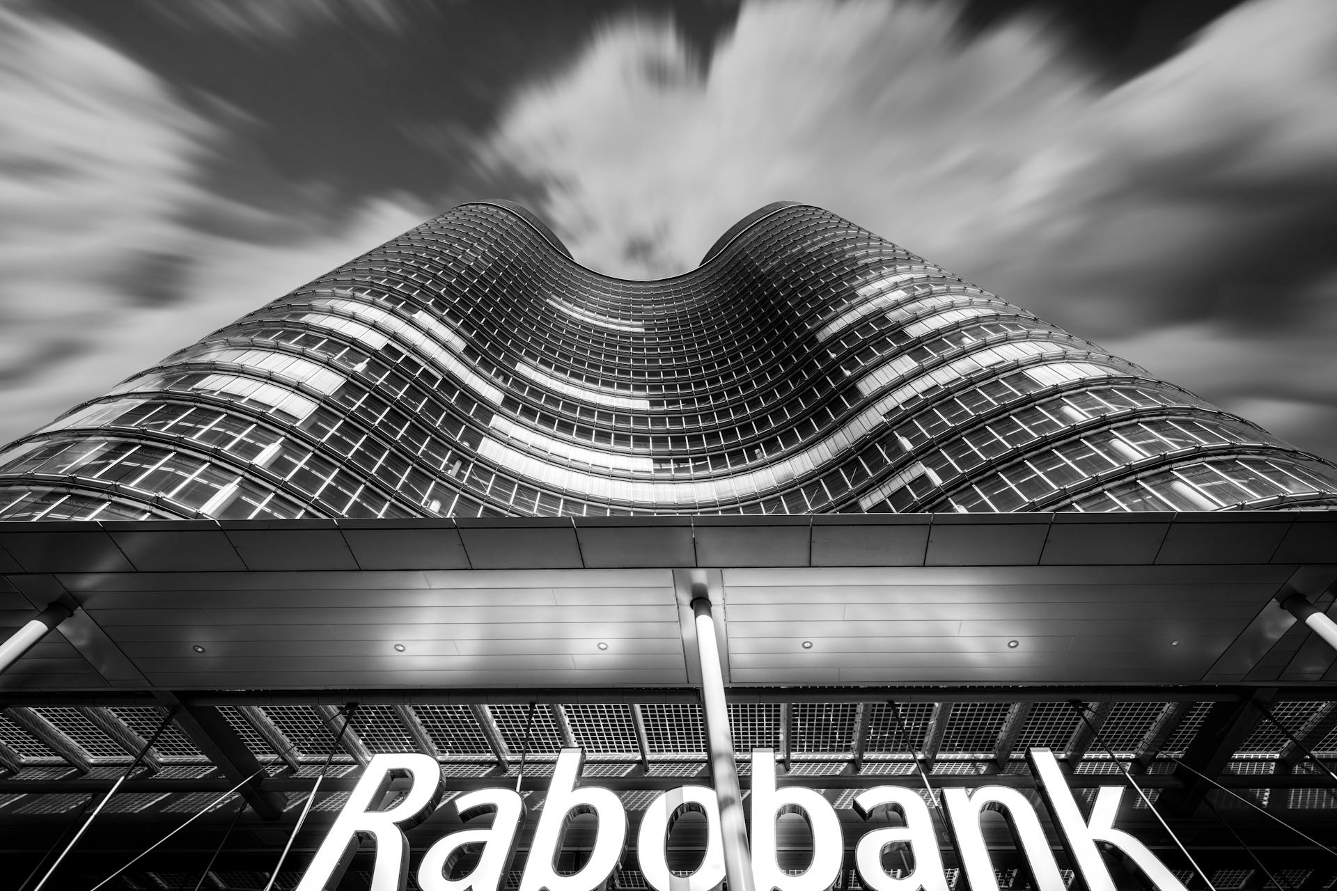 Striking low angle shot of Rabobank building in Utrecht, Netherlands, with dramatic sky.