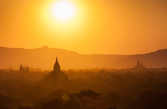 Silhouette of Bagan temples at sunset with golden skies and landscape.