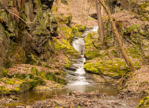 Waterfall and River Between Mossy Rocks