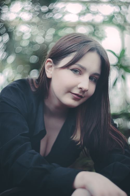 Free Enchanting portrait of a caucasian woman outdoors with a lush, blurred background. Stock Photo