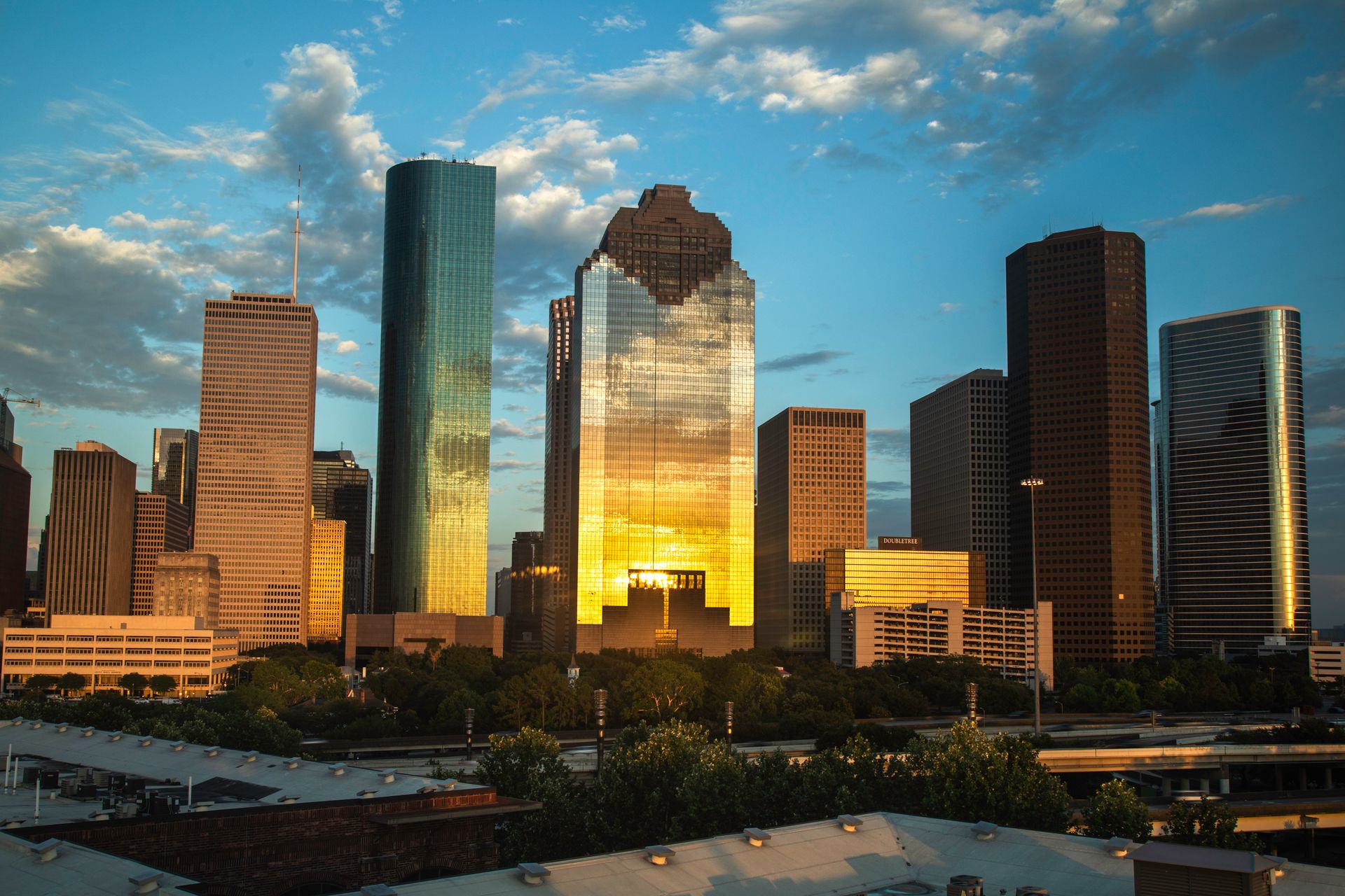 Dallas skyline at golden hour with downtown towers reflected in afternoon light, Trinity River visible