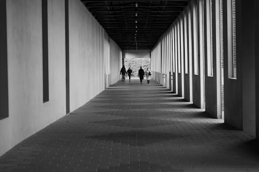 Black and white photo of people walking in a corridor in Antwerp, Belgium.