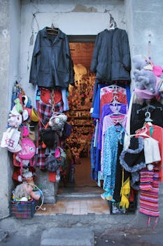 Vibrant doorway of a Tbilisi shop displaying clothing and stuffed toys.