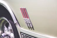 特写镜头聚焦于一辆以赛车条纹为特色的老爷车标志，凸显其经典设计