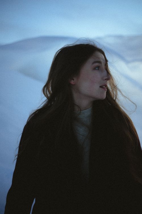Free A woman with long hair gazes over her shoulder in a winter scene. Stock Photo
