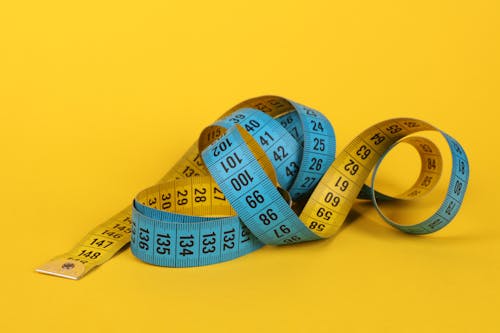 Free Tape Measure on Yellow Background Stock Photo