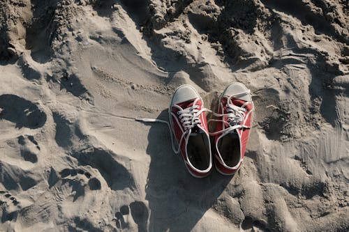 Free White and Red Shoes on Gray Sand Stock Photo