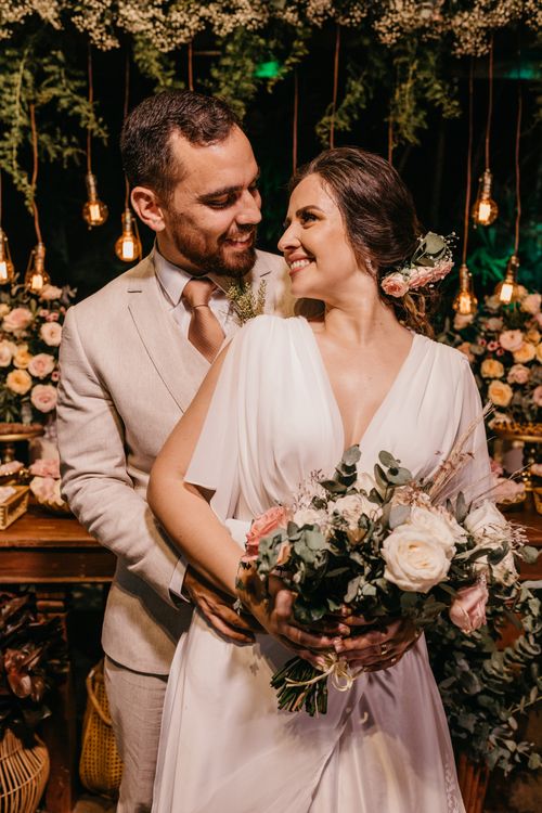 Free A newlywed couple in a romantic embrace at their wedding ceremony indoors at night. Stock Photo