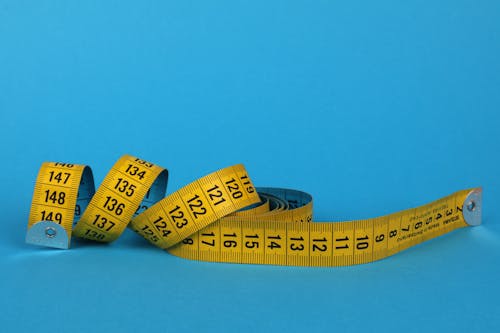 Yellow and Black Tape Measure on Blue Background 