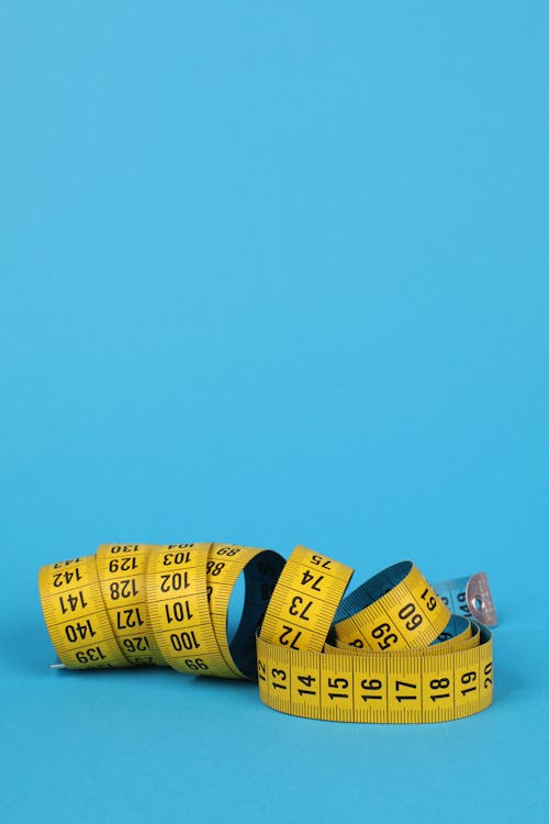 Free Yellow and Black Tape Measure on Blue Surface Stock Photo