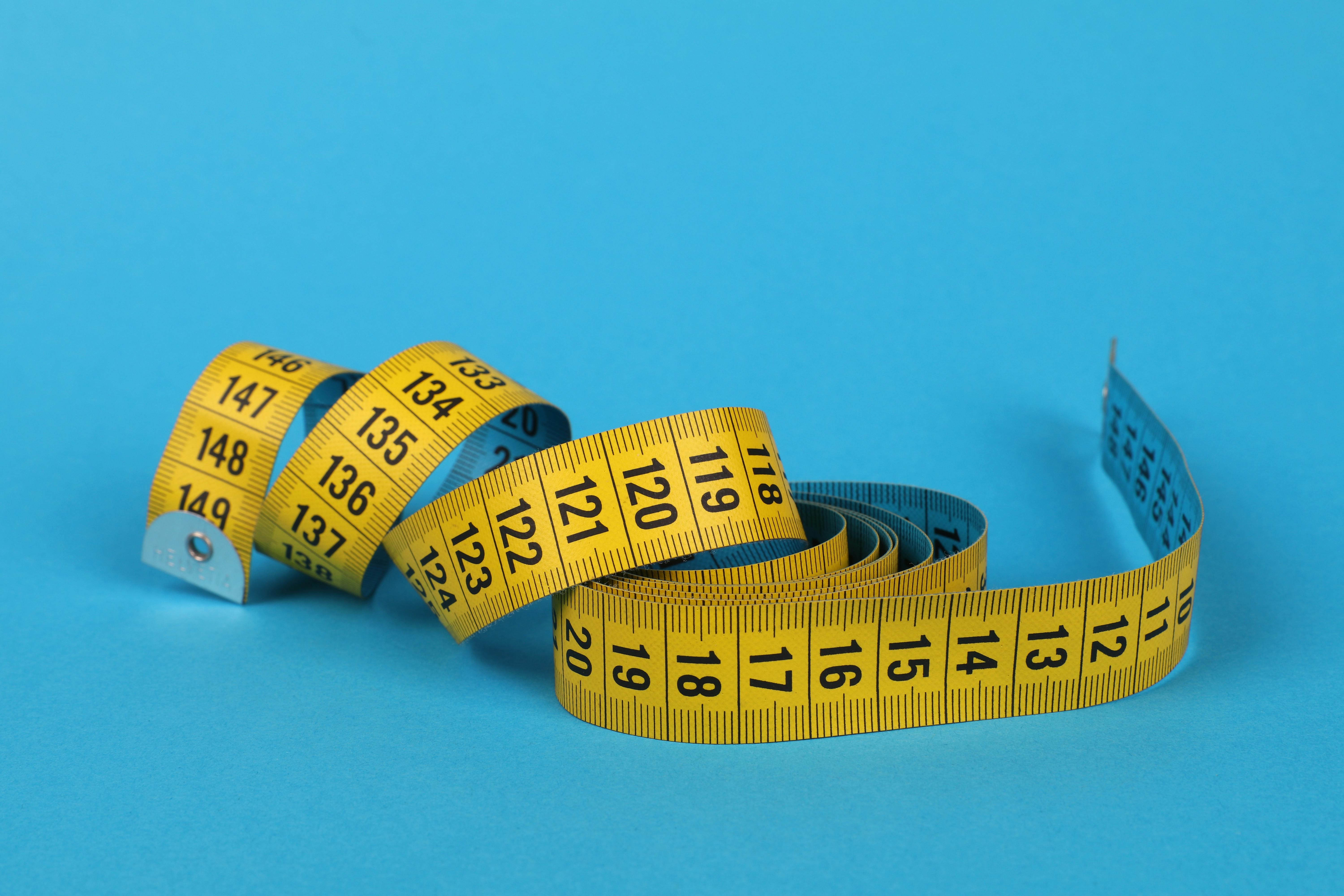 Yellow Centimeter Tape Measure On Blue Background Stock Photo, Picture and  Royalty Free Image. Image 163071903.