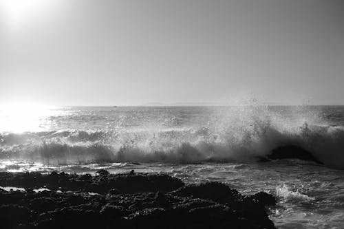 Ocean Waves Crashing on Rocks in Grayscale Photography