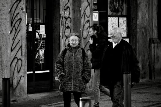 Charming street scene with an elderly couple walking together, captured in monochrome.