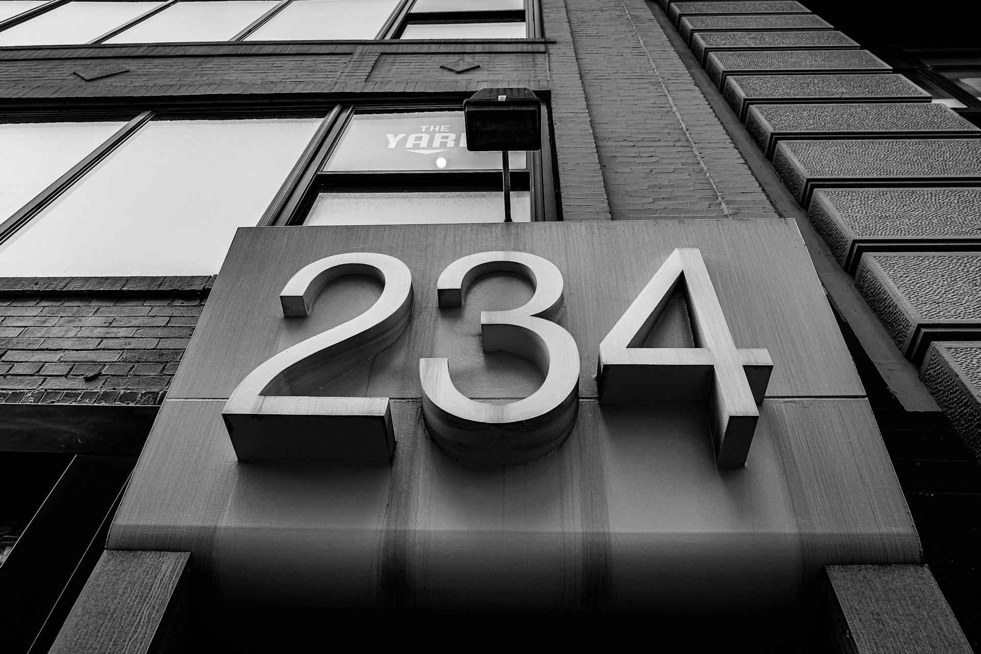 Monochrome view of a building facade showcasing a large 234 address number.