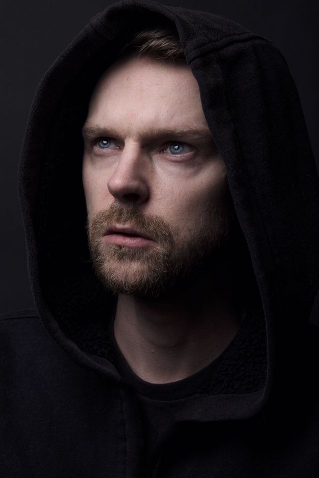 Close portrait of a model in a raised hood, low winter light — photo by Sammie Sander on Pexels