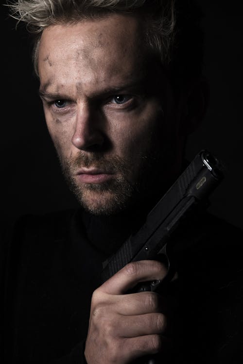 Portrait of a Man Holding a Black Pistol