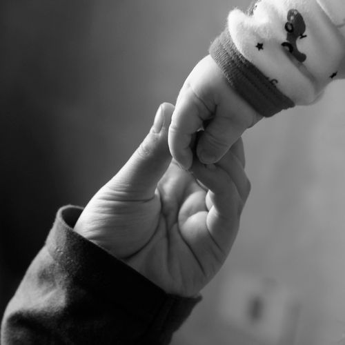 Free Tender black and white image of a baby holding an adult's hand, symbolizing touch and connection. Stock Photo