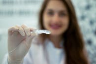 Woman Wearing Gloves Holding a Plastic Retainer