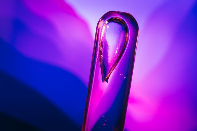 Glass vial of serum lit in violet — photo by Jan Kopřiva on Pexels