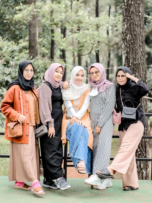 Free Five women in hijabs posing together outdoors among trees, showcasing friendship and fashion. Stock Photo