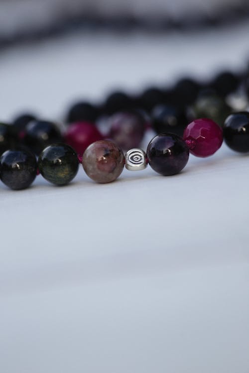 Free Purple and Black Beads on White Surface Stock Photo