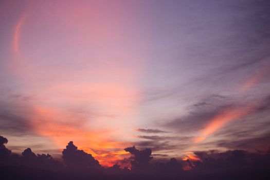 Stunning twilight sky showcasing vibrant hues of pink, purple, and orange with scattered clouds.
