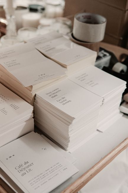 Stacks of minimalist printed invitations organized in a studio setting, ideal for business and design concepts.