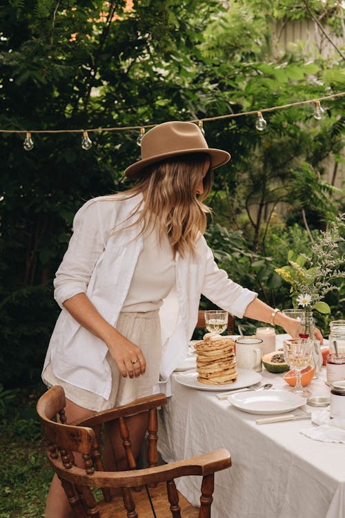 Free Woman Setting Vase with Flower on Table Stock Photo