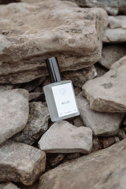 Free Stylish perfume bottle set on rugged rocks, evokes natural elegance and earthy tones. Stock Photo
