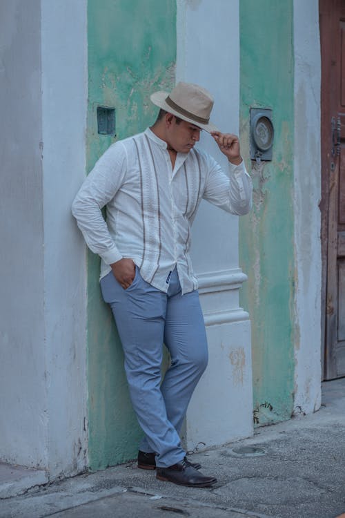 Free Man in White Long Sleeve Shirt and Blue Pants Posing Beside the Wall  Stock Photo