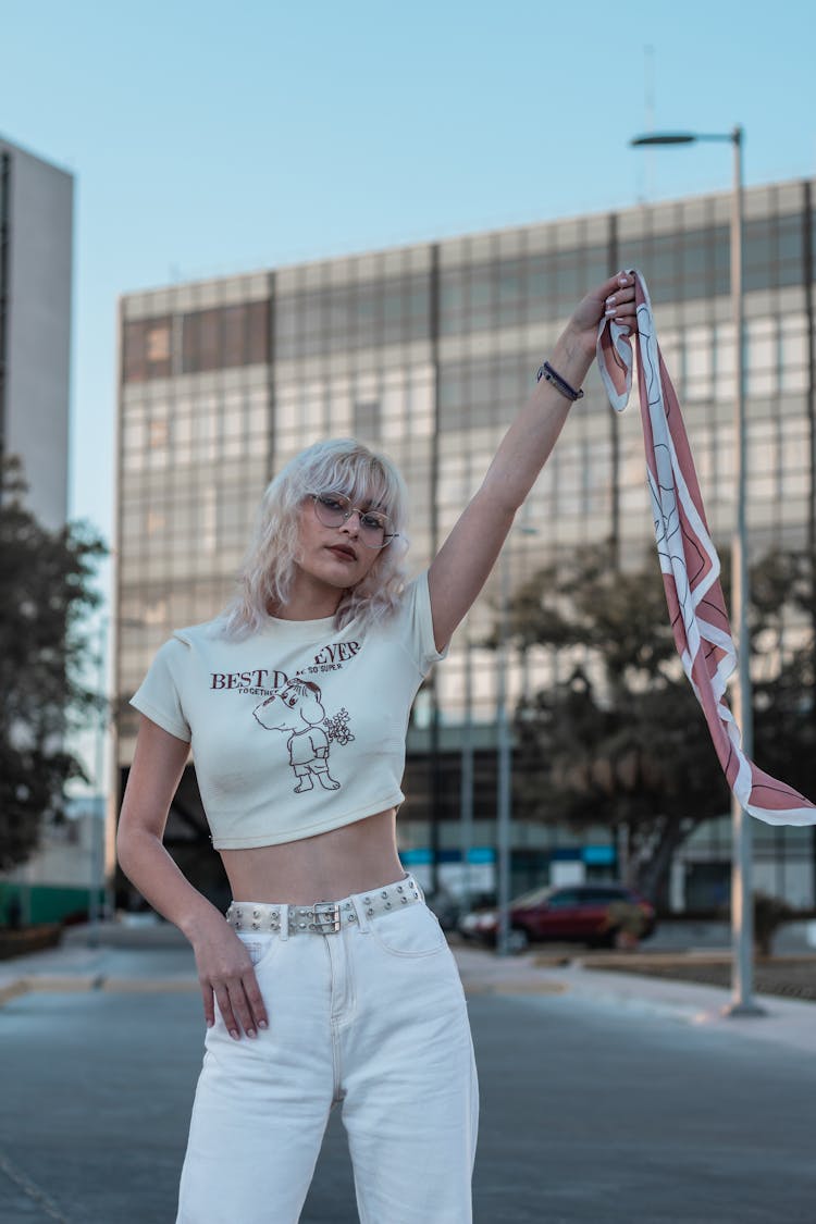 Woman In A Shirt And White Pants Holding A Handkerchief