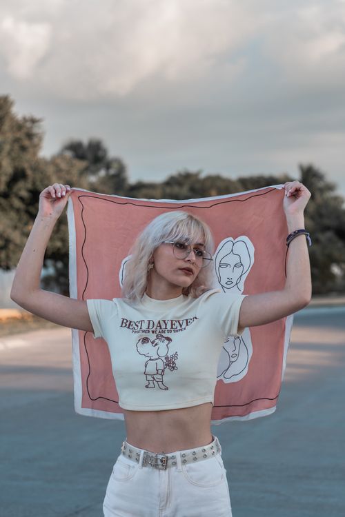 Free Blonde woman outdoors holding a scarf with artistic design, featuring text 'Best Day Ever.' Stock Photo
