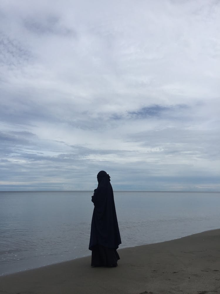 Woman Wearing An Abaya Standing At A Beach