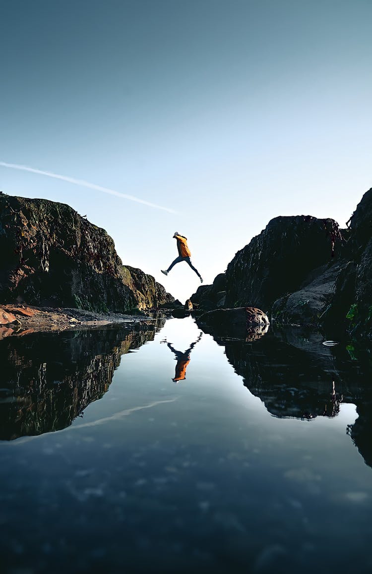 Person Jumping From A Rock