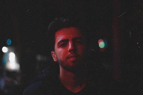 Free Artistic portrait of a bearded man at night with dramatic lighting and bokeh effects. Stock Photo