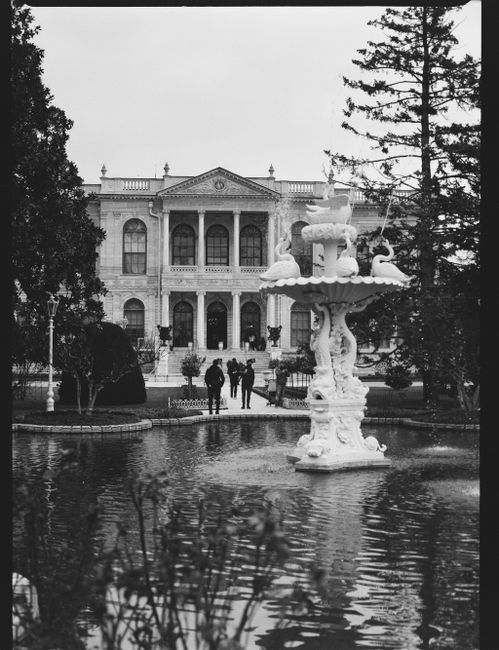 Stunning grayscale image of a historical mansion with a decorative fountain in Istanbul.