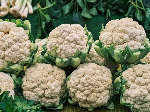 Free A vivid, close-up view of fresh cauliflower bunches on display at a market. Stock Photo