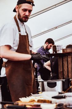 Dynamic scene of chefs preparing food at a culinary event in Rømø, Denmark.