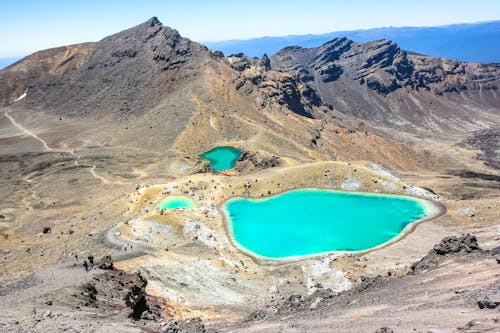 Bodies of Water Surrounding Mountain during Daytime